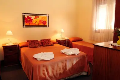 a hotel room with two beds with towels on them at Embajador Hotel in Villa Carlos Paz