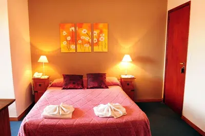 a bedroom with a bed with two towels on it at Embajador Hotel in Villa Carlos Paz