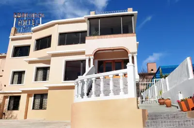 a large white building with a staircase in front of it at Embajador Hotel in Villa Carlos Paz