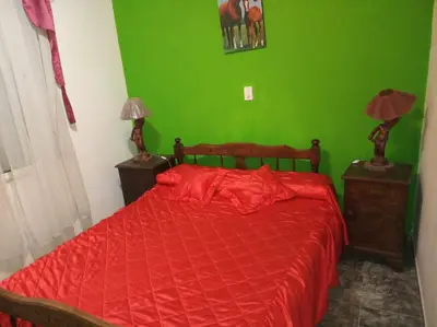 a bedroom with a red bed with a green wall at Casa Reinamora in Villa Parque Siquiman