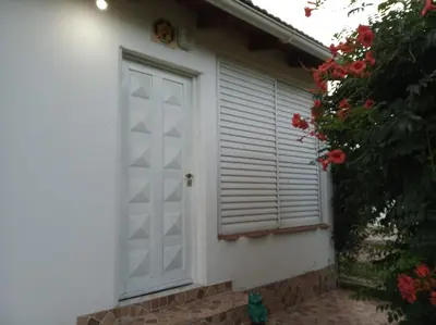 a white garage door with a window and a bush at Casa Reinamora in Villa Parque Siquiman