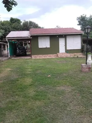 a house with a car parked in the yard at Casa Reinamora in Villa Parque Siquiman