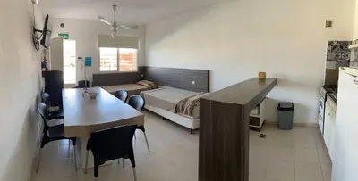 a room with a bed and a table and a kitchen at Sierras Apartamentos in Villa Santa Cruz del Lago
