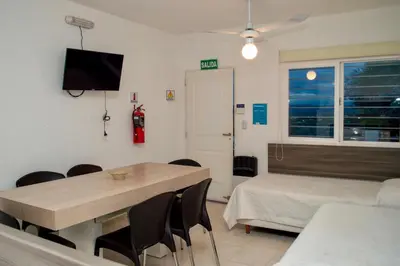 a room with a table and a bed and a tv at Sierras Apartamentos in Villa Santa Cruz del Lago