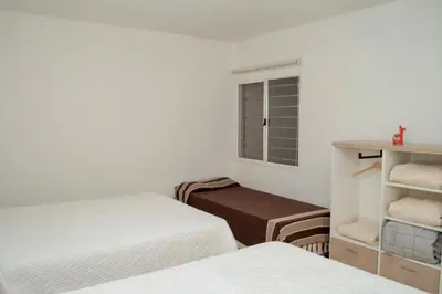 a small bedroom with two beds and a window at Sierras Apartamentos in Villa Santa Cruz del Lago