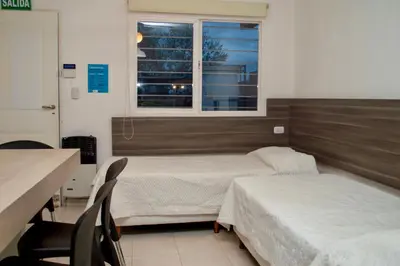 a hospital room with two beds and a window at Sierras Apartamentos in Villa Santa Cruz del Lago