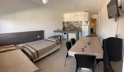 a room with a bed and a table with chairs at Sierras Apartamentos in Villa Santa Cruz del Lago