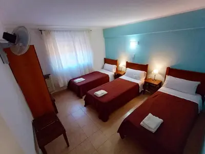 a hotel room with two beds and a window at Hosteria Valle Azul in Villa del Dique