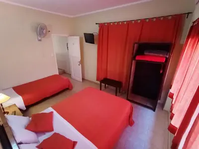 a room with two beds and a red curtain at Hosteria Valle Azul in Villa del Dique