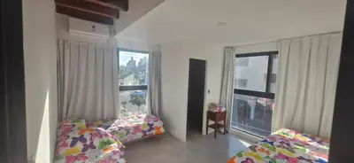 a bedroom with two beds and a large window at Vivisierras, Duplex a estrenar con pileta privada centro Villa Carlos Paz, 3 dormitorios, 2 baños, vista in Villa Carlos Paz