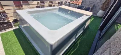 a hot tub on a balcony with green grass at Vivisierras, Duplex a estrenar con pileta privada centro Villa Carlos Paz, 3 dormitorios, 2 baños, vista in Villa Carlos Paz