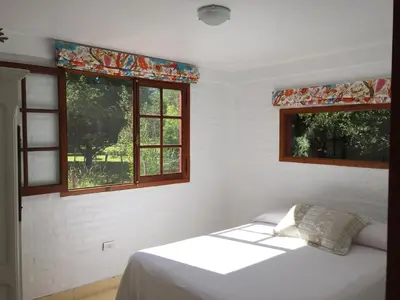 a bedroom with a bed and two windows at Raco De La Calma in Nono