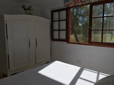 a bedroom with a white cabinet and two windows at Raco De La Calma in Nono