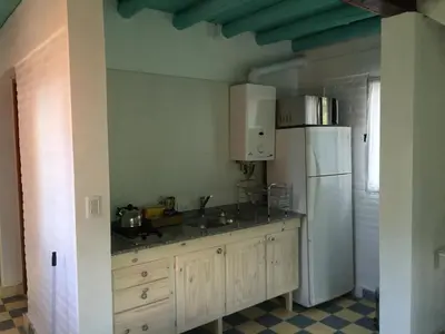 a kitchen with a white refrigerator and a sink at Raco De La Calma in Nono