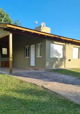 a house with a driveway in front of it at Cabañas Cuncumen in Los Reartes