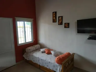 a small bedroom with a bed and a window at Cabañas Cuncumen in Los Reartes