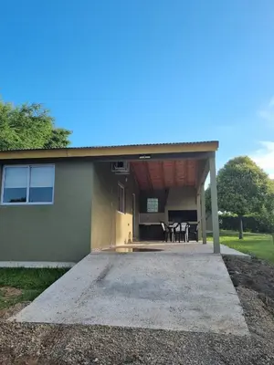 a house with a porch with a table in it at Cabañas Cuncumen in Los Reartes