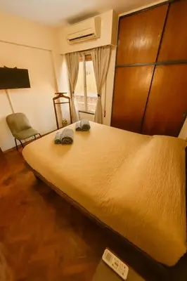 a bedroom with a large bed and a chair at Apartamento Andres in Cordoba