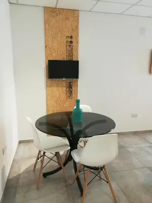 a dining room with a black table and white chairs at EFE Aparts in Mina Clavero