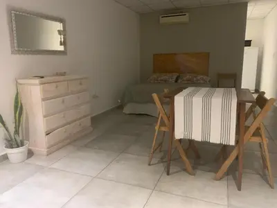 a bedroom with a bed and a table and a dresser at EFE Aparts in Mina Clavero