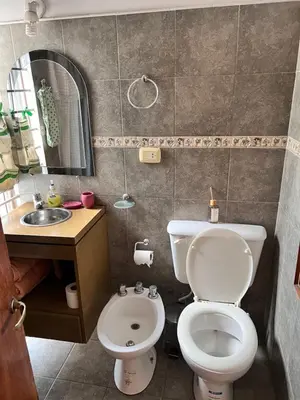 a bathroom with a toilet and a sink and a mirror at Alojamiento Cba Observatorio in Cordoba
