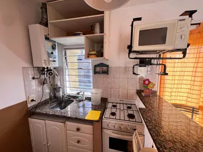 a small kitchen with a stove and a microwave at Alojamiento Cba Observatorio in Cordoba