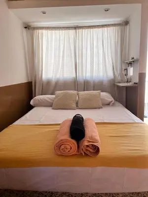 a bed with a towel on it with a window at Alojamiento Cba Observatorio in Cordoba