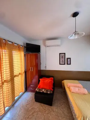 a bedroom with two beds and a couch and a television at Alojamiento Cba Observatorio in Cordoba