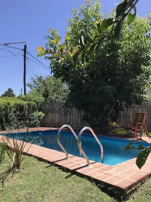 a swimming pool with a metal rail in a yard at Casa Las Magnolias in Villa General Belgrano