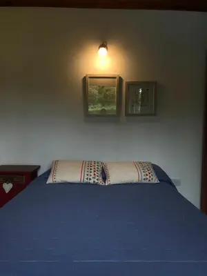 a bedroom with a blue bed with two pictures on the wall at Casa Las Magnolias in Villa General Belgrano