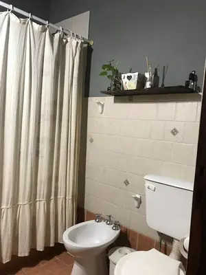 a bathroom with a toilet and a shower curtain at Casa Las Magnolias in Villa General Belgrano
