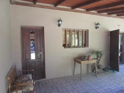 a room with a table and a door and a table and a chair at Casa Las Magnolias in Villa General Belgrano