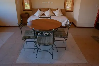 a table and chairs in a room with a bed at La Quinta Resort in Merlo