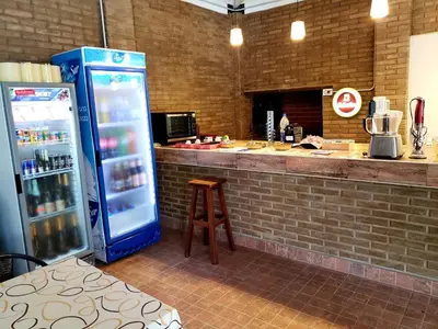 a kitchen with a counter with a refrigerator and a stool at Al Rio Suites in Nono