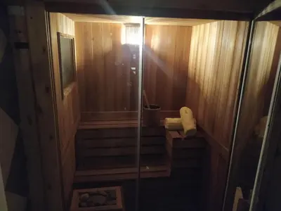 a walk in shower in a wooden bathroom with stairs at Al Rio Suites in Nono