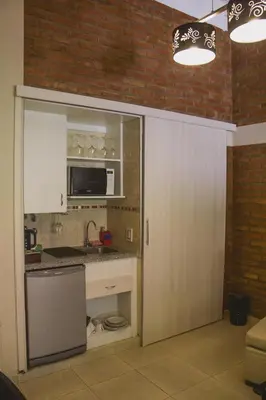 a kitchen with a sink and a microwave at Al Rio Suites in Nono
