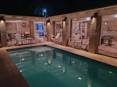 a swimming pool with chairs and a table at Al Rio Suites in Nono