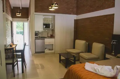 a bedroom with a bed and a kitchen and a dining room at Al Rio Suites in Nono
