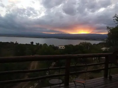 a view of a sunset from the balcony of a house at Peperina Lago Los Molinos in Villa Ciudad de America