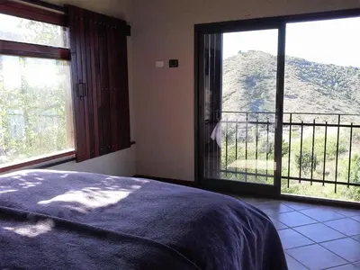 a bedroom with a large window with a view of a mountain at Peperina Lago Los Molinos in Villa Ciudad de America