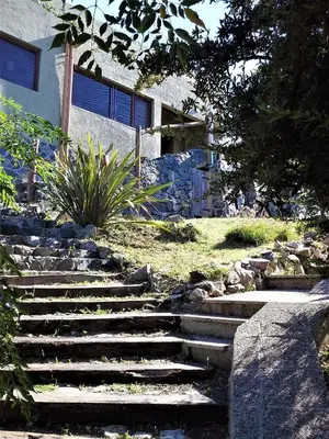 a set of stone stairs in front of a house at Peperina Lago Los Molinos in Villa Ciudad de America