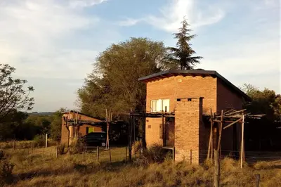 an old brick building sitting in a field at Cabaña La Miranta in Los Reartes