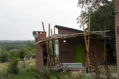 a small brick building with a green door at Cabaña La Miranta in Los Reartes
