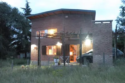 a small brick house with the lights on at Cabaña La Miranta in Los Reartes