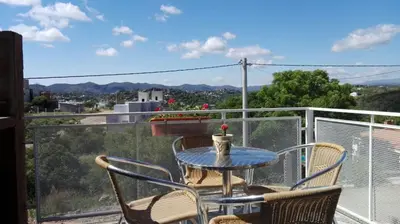 a table and chairs on a balcony with a view at Duplex la Delfina 1 in Villa Carlos Paz