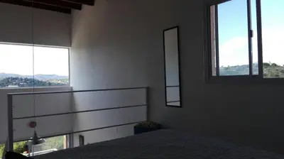 a bedroom with two windows and a bed in it at Duplex la Delfina 1 in Villa Carlos Paz