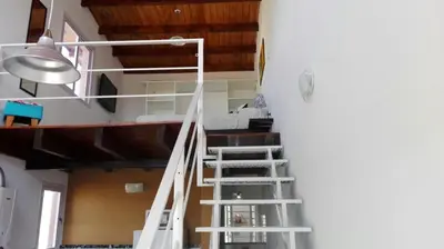 a white staircase in a room with a ceiling at Duplex la Delfina 1 in Villa Carlos Paz