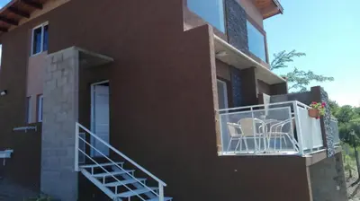 a house with a balcony with chairs on it at Duplex la Delfina 1 in Villa Carlos Paz