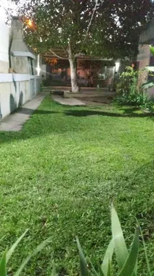 a yard with green grass and a house at Departamento El Nogal in Alta Gracia
