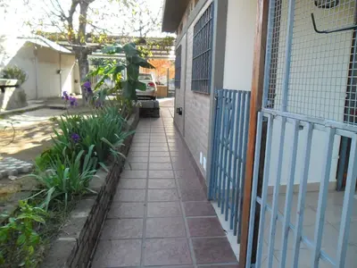 a walkway outside of a house with a blue gate at Departamento El Nogal in Alta Gracia